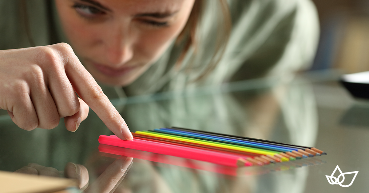 Lady lining up a number of coloured pencils