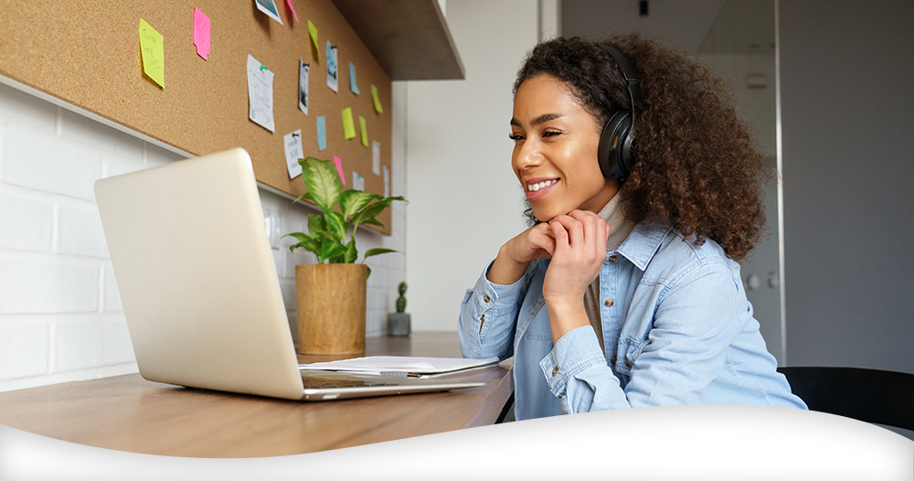 Lady wearing headset sat in front of a laptop